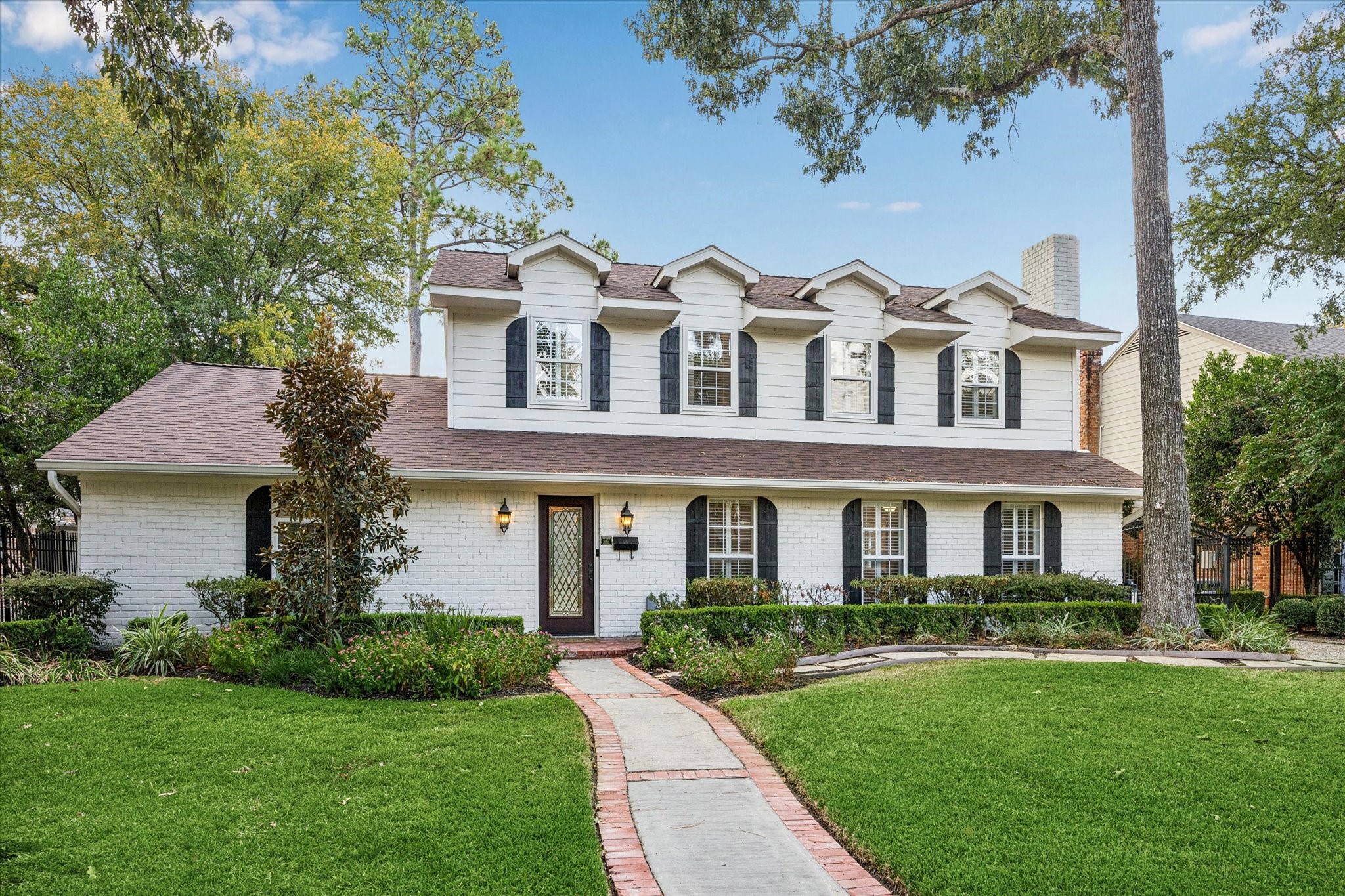 13403 Taylorcrest Road Houston, TX 77079 - Photo 1 of 38 a front view of a house with a garden and trees
