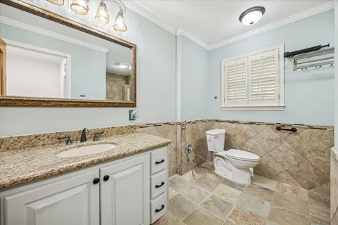 a bathroom with a granite countertop sink mirror vanity and toilet