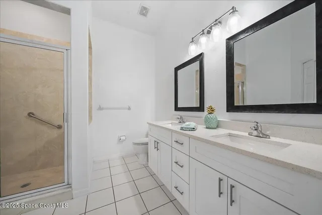 a spacious bathroom with a double vanity sink mirror and shower