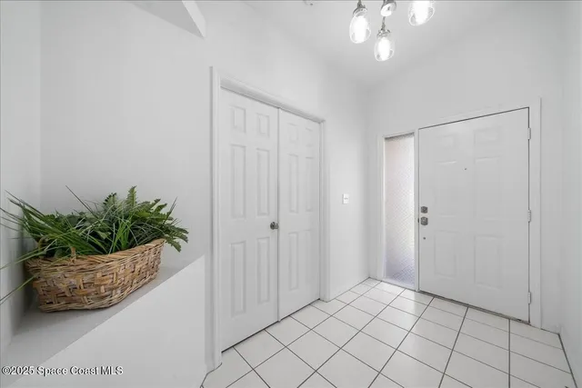 a room that has a potted plant and chandelier