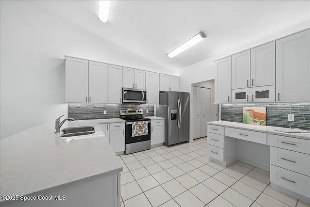 a kitchen with white cabinets and stainless steel appliances