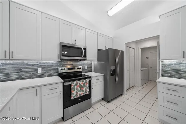 a kitchen with stainless steel appliances white cabinets and a refrigerator