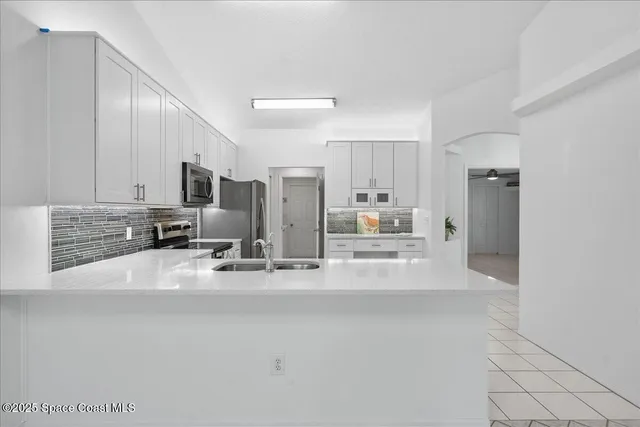 a view of kitchen with refrigerator and window