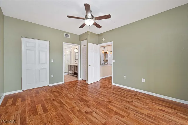 a view of a livingroom with a ceiling fan wooden floor and a ceiling fan