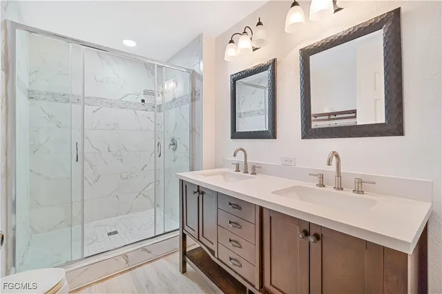 a bathroom with a double vanity sink mirror and shower