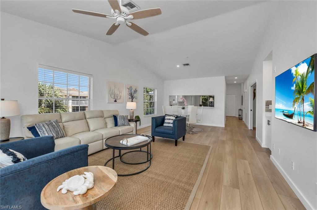 6010 Chardonnay Lane, Unit 304 Naples, FL 34119 - Photo 2 of 29 a living room with furniture a flat screen tv and a large window
