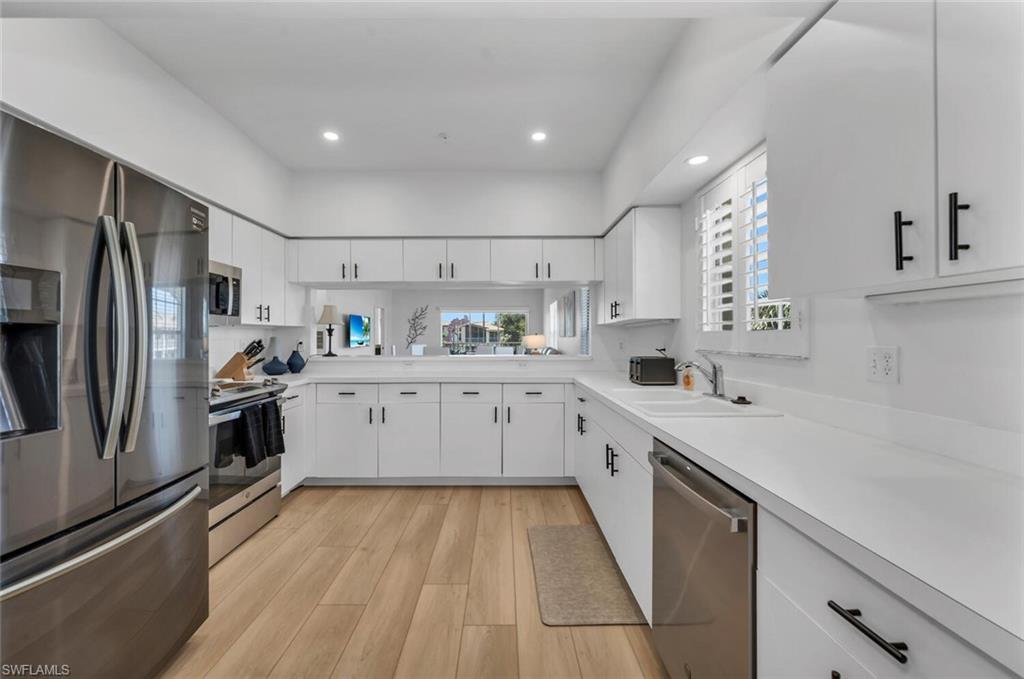 6010 Chardonnay Lane, Unit 304 Naples, FL 34119 - Photo 3 of 29 a kitchen with a sink stainless steel appliances and white cabinets
