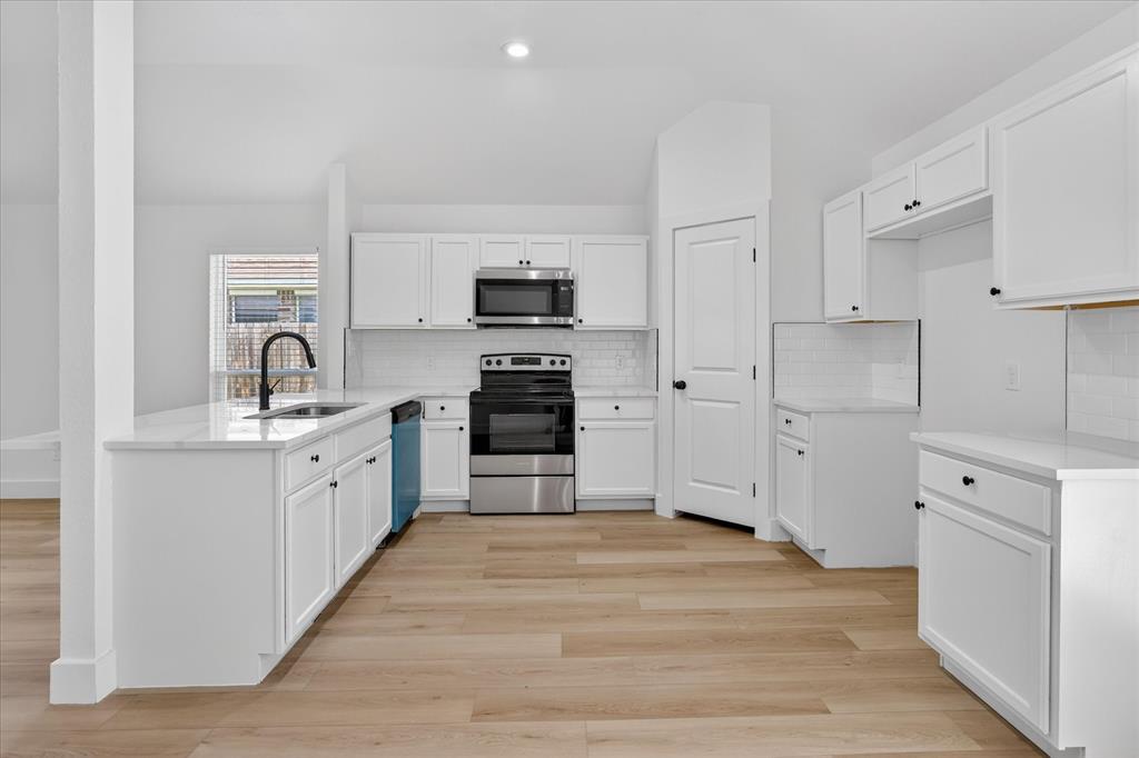 6021 Hartman Road Forest Hill, TX 76119 - Photo 11 of 27 a kitchen with white cabinets and stainless steel appliances