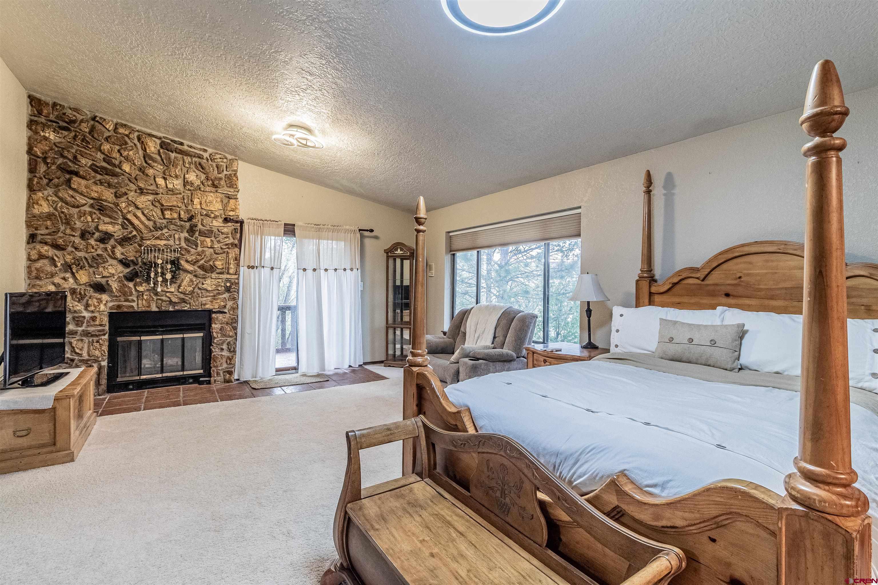 27 Road 3025 Aztec, NM 87410 - Photo 29 of 45 a bedroom with furniture and a fireplace