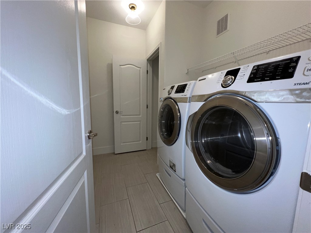1705 King James Street, Unit 203 Las Vegas, NV 89144 - Photo 14 of 21 Laundry room with washer and clothes dryer and baseboards