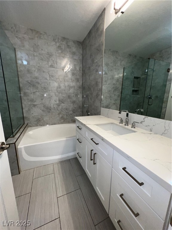 1705 King James Street, Unit 203 Las Vegas, NV 89144 - Photo 19 of 21 Bathroom with vanity, a stall shower, a garden tub, and a textured ceiling