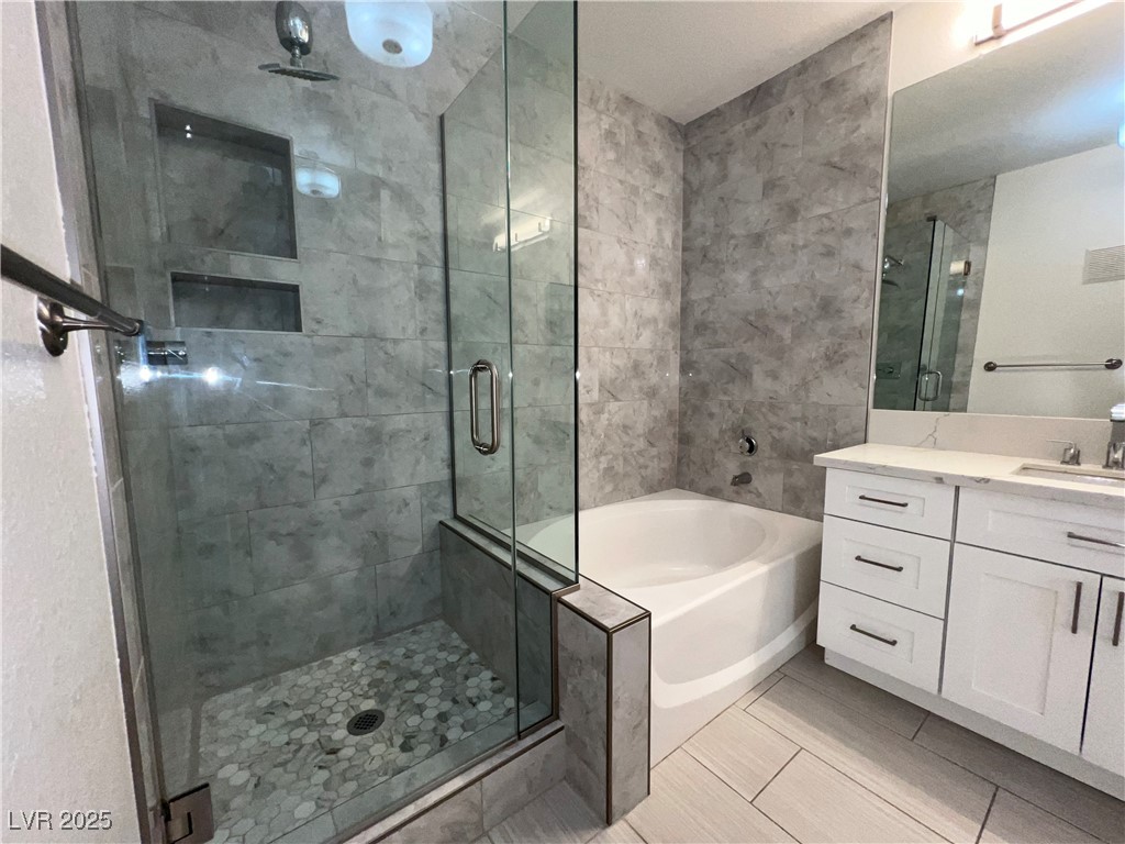 1705 King James Street, Unit 203 Las Vegas, NV 89144 - Photo 20 of 21 Bathroom featuring a bath, vanity, a stall shower, and light tile patterned floors