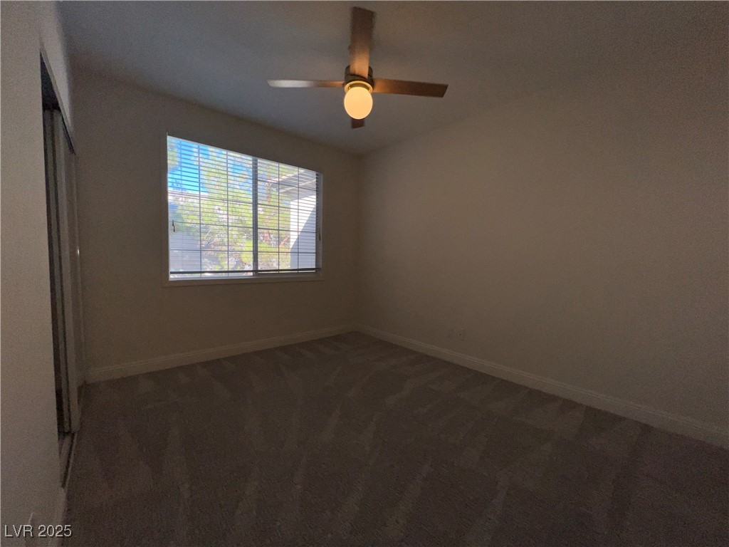 1705 King James Street, Unit 203 Las Vegas, NV 89144 - Photo 10 of 21 Unfurnished bedroom with dark carpet, a ceiling fan, and a closet