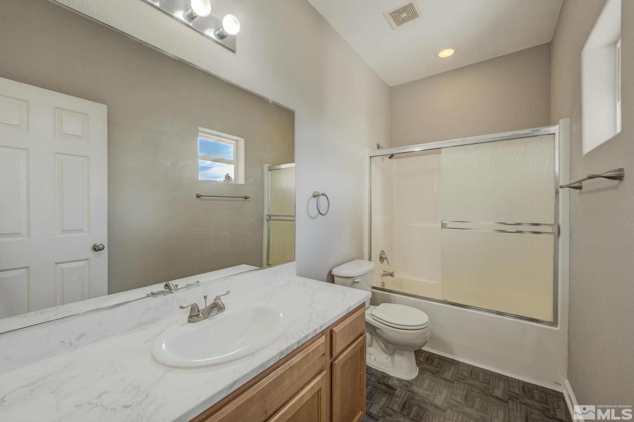 5155 Emery Drive Reno, NV 89506 - Photo 21 of 38 a bathroom with a granite countertop sink toilet and shower