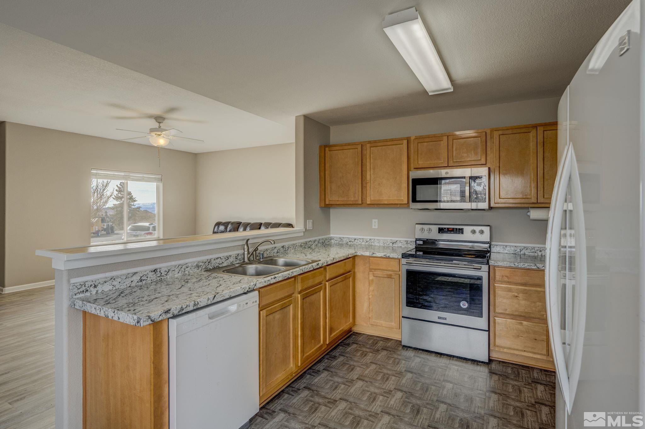 5155 Emery Drive Reno, NV 89506 - Photo 5 of 38 a kitchen with stainless steel appliances granite countertop a sink stove microwave and cabinets