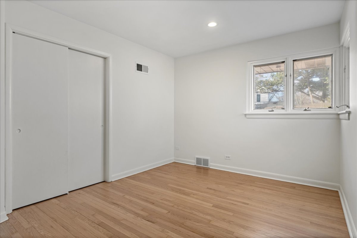 8314 Gross Point Road Morton Grove, IL 60053 - Photo 13 of 28 wooden floor in an empty room with a window