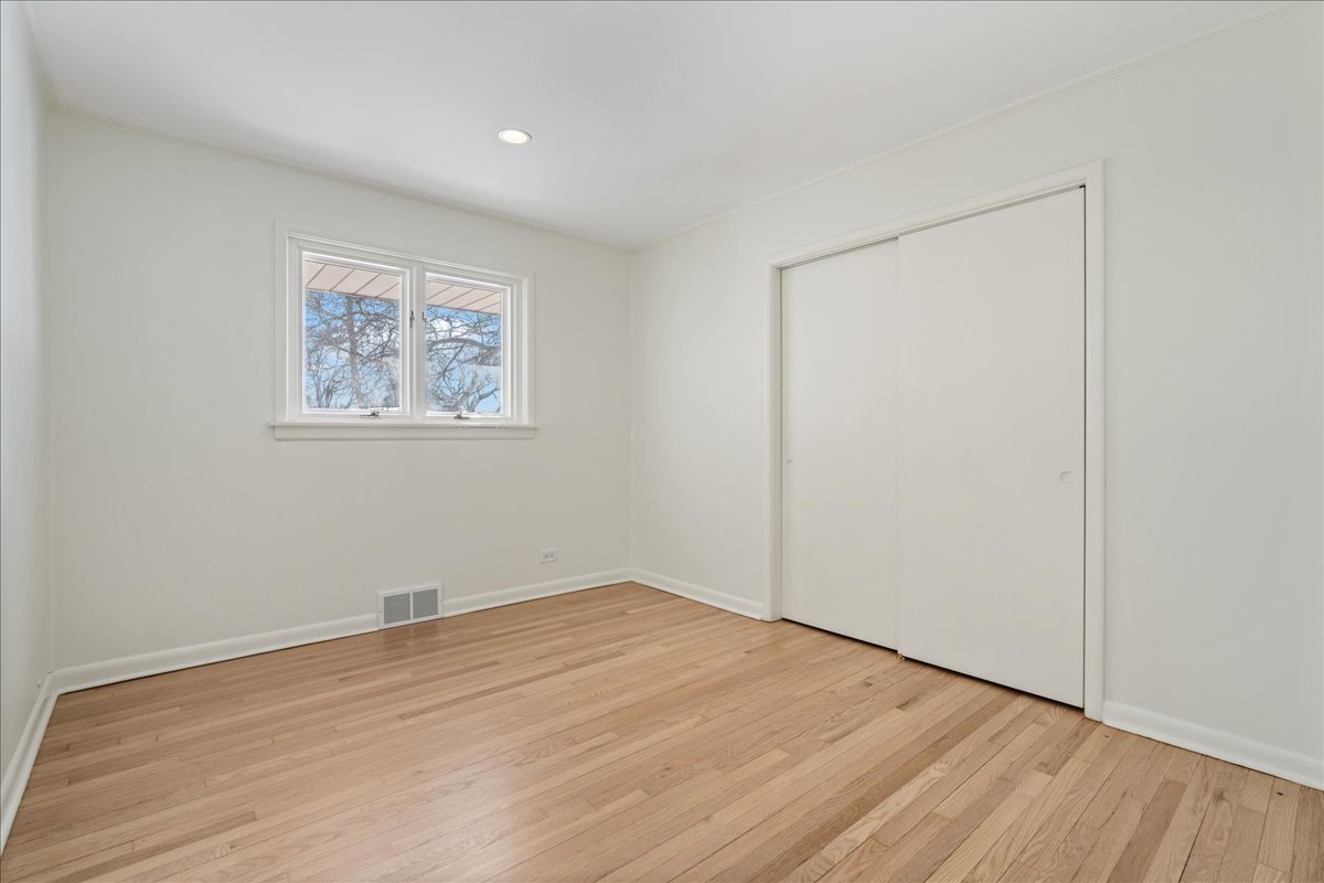 8314 Gross Point Road Morton Grove, IL 60053 - Photo 15 of 28 an empty room with wooden floor and windows