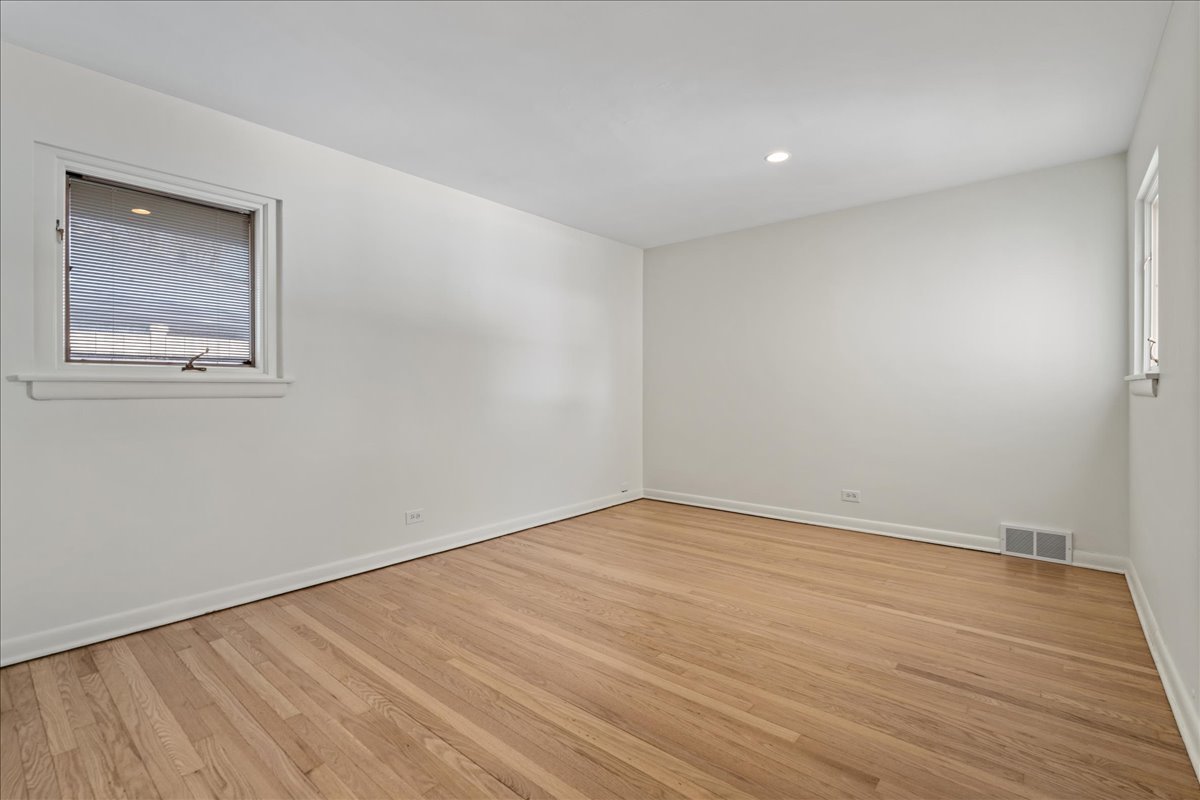 8314 Gross Point Road Morton Grove, IL 60053 - Photo 18 of 28 a view of an empty room with wooden floor and a window