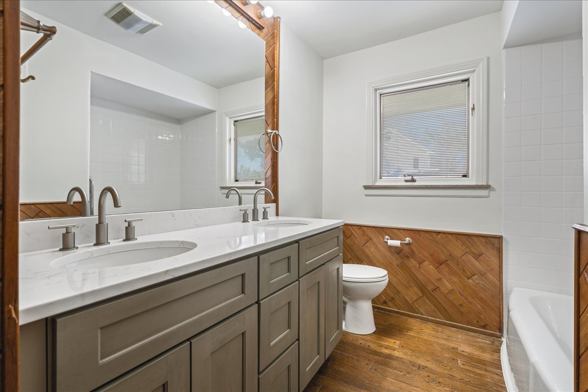 8314 Gross Point Road Morton Grove, IL 60053 - Photo 23 of 28 a bathroom with a double vanity sink and a mirror