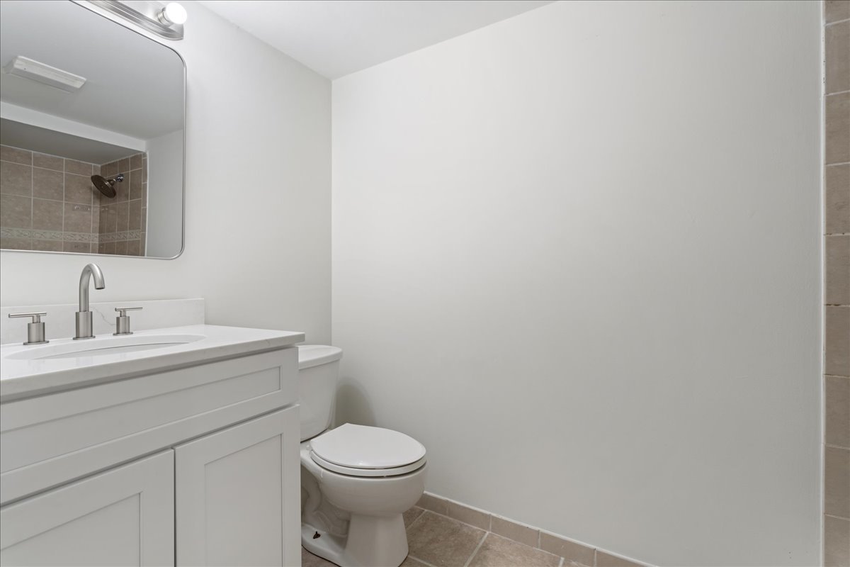 8314 Gross Point Road Morton Grove, IL 60053 - Photo 24 of 28 a bathroom with a toilet a sink and mirror