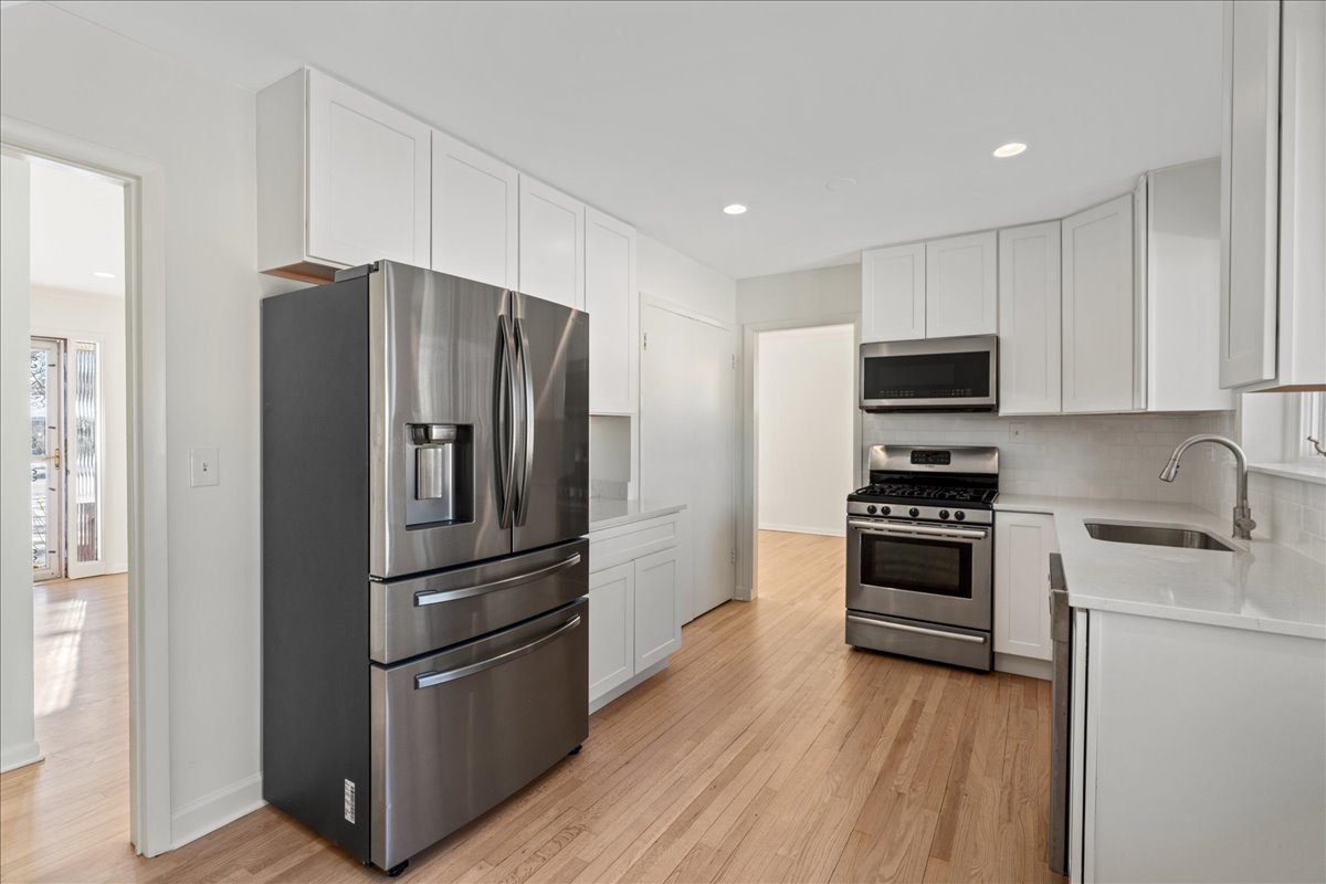 8314 Gross Point Road Morton Grove, IL 60053 - Photo 8 of 28 a kitchen with granite countertop a refrigerator and a stove top oven