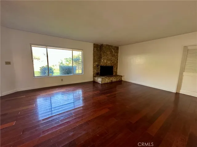 a living room with hard wood floors and a fireplace