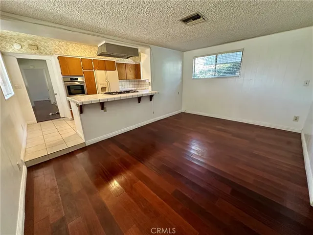 a view of a living room with wooden floor and a window