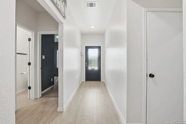 a view of a hallway with wooden floor
