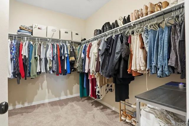 a view of walk in closet with clothes