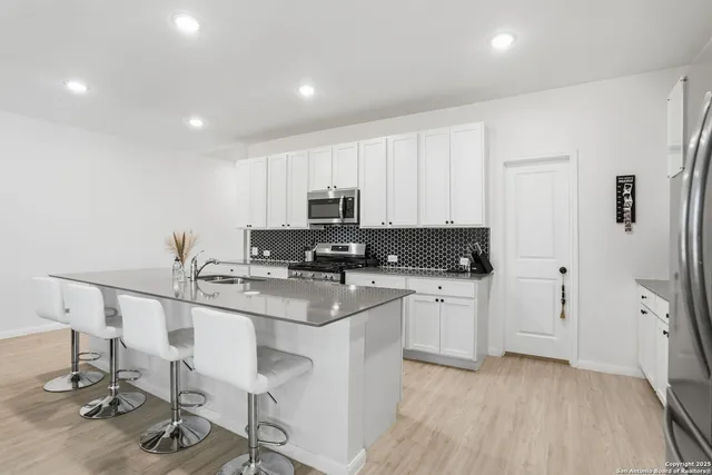 a kitchen with a sink cabinets and wooden floor