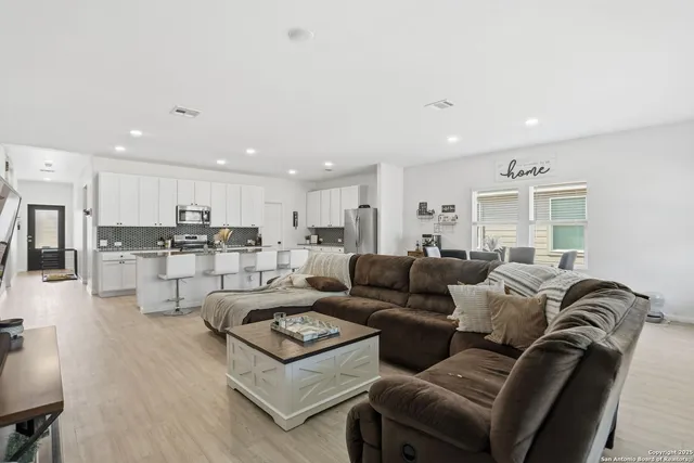 a living room with furniture with kitchen view and a view of kitchen