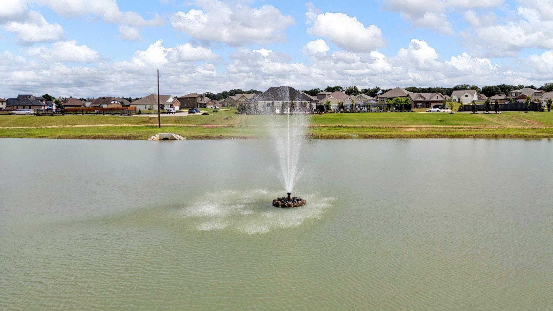 980 Mewborn Farm Road Oakland, TN 38060 - Photo 27 of 34 Pond with an active fountain, surrounded by a grassy bank and residential properties