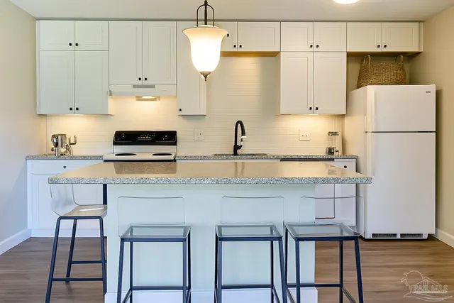 a kitchen with stainless steel appliances granite countertop a sink a refrigerator and a stove