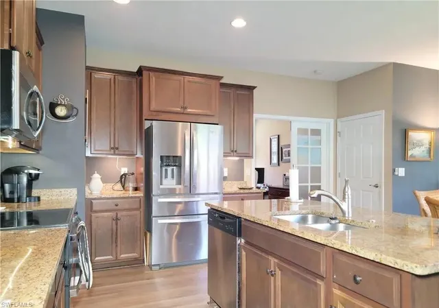 a kitchen with granite countertop a refrigerator and a stove top oven