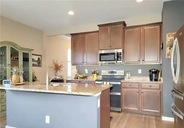 a kitchen with stainless steel appliances granite countertop a sink stove and microwave