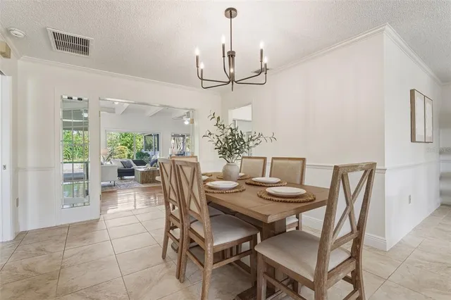 a view of a dining room with furniture a chandelier and wooden floor