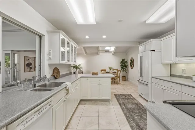 a kitchen with kitchen island granite countertop a refrigerator oven a sink and dishwasher