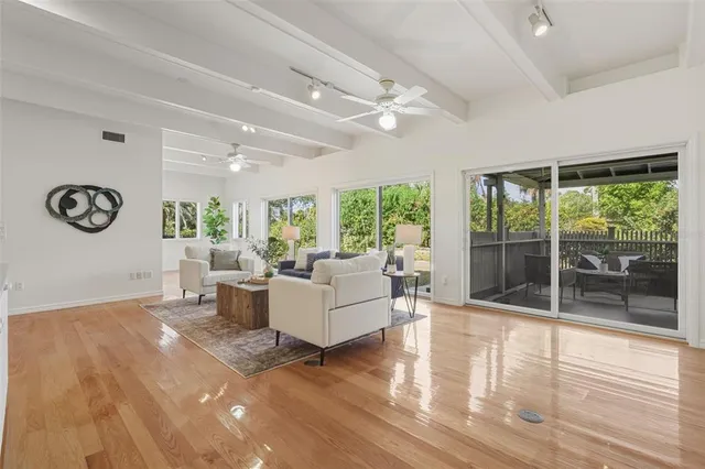 an empty room with windows and fan