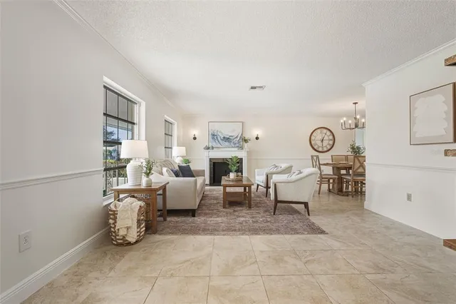 a living room with furniture a fireplace and a large window