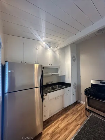 a kitchen with granite countertop a refrigerator and a sink