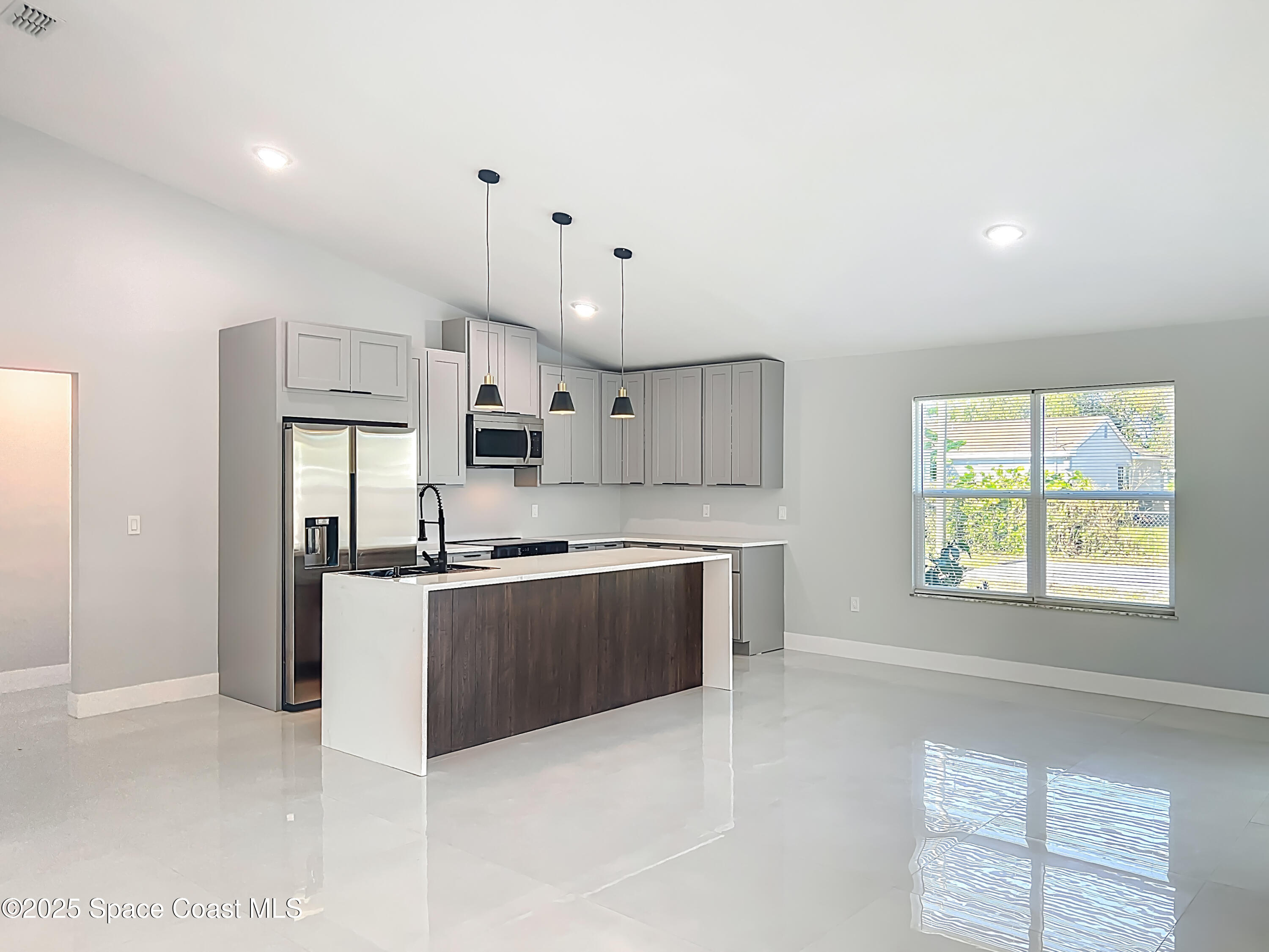 1911 Academy Street Northeast Palm Bay, FL 32905 - Photo 13 of 65 a large kitchen with stainless steel appliances kitchen island granite countertop a stove a sink a refrigerator and a granite counter tops with white cabinets