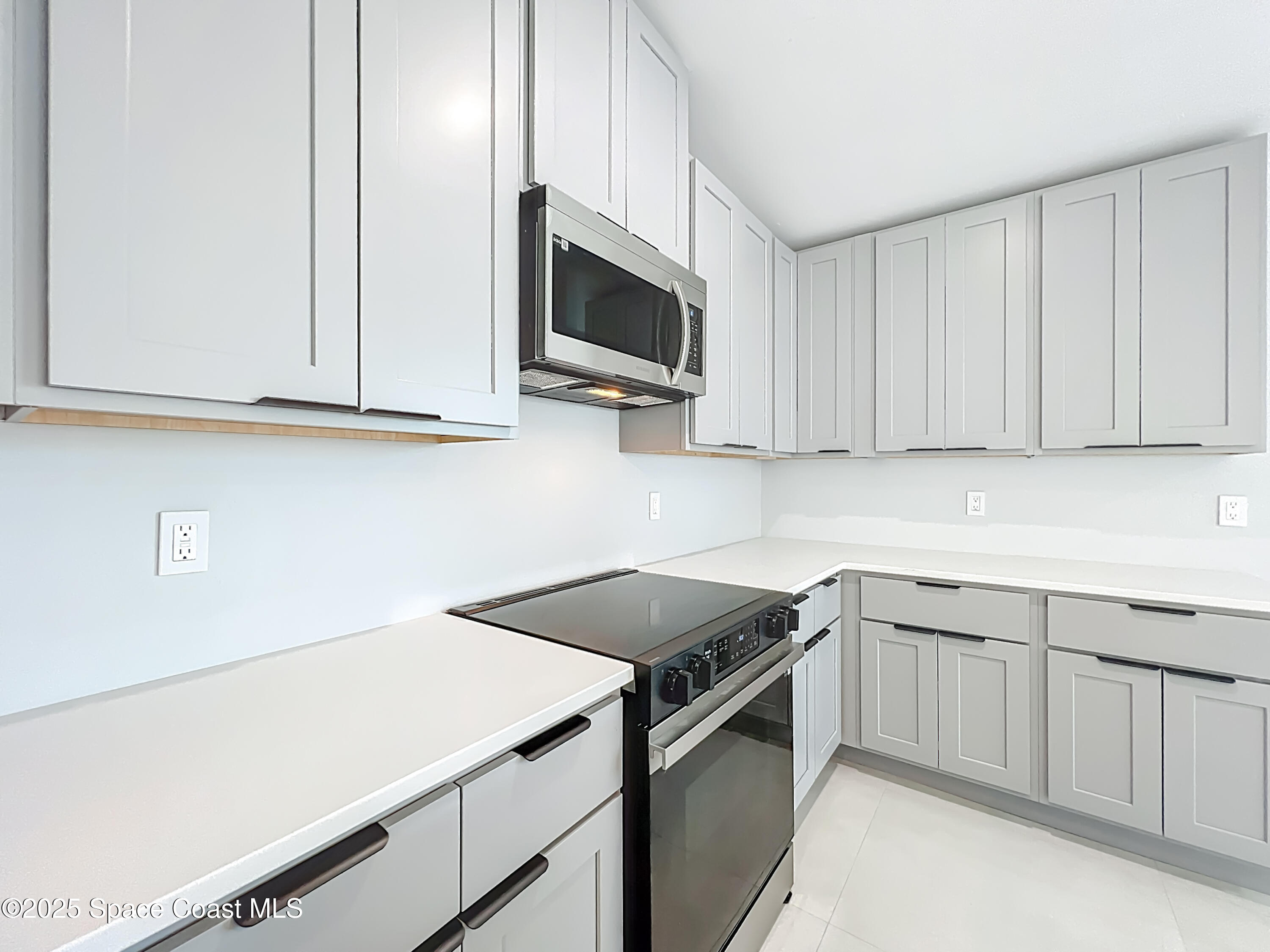 1911 Academy Street Northeast Palm Bay, FL 32905 - Photo 18 of 65 a kitchen with stainless steel appliances granite countertop a sink a stove a microwave oven with white cabinets