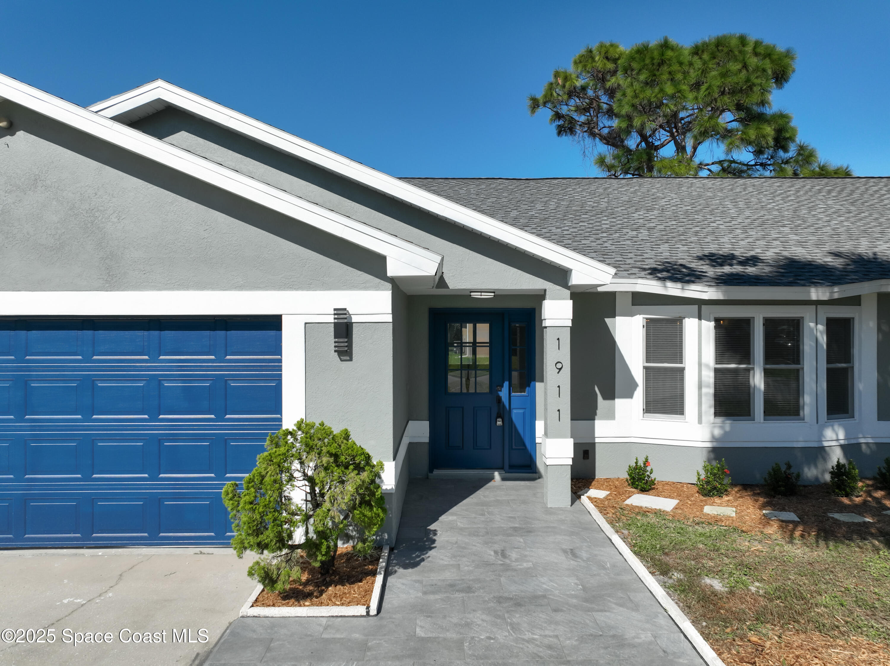 1911 Academy Street Northeast Palm Bay, FL 32905 - Photo 2 of 65 a front view of a house with garden