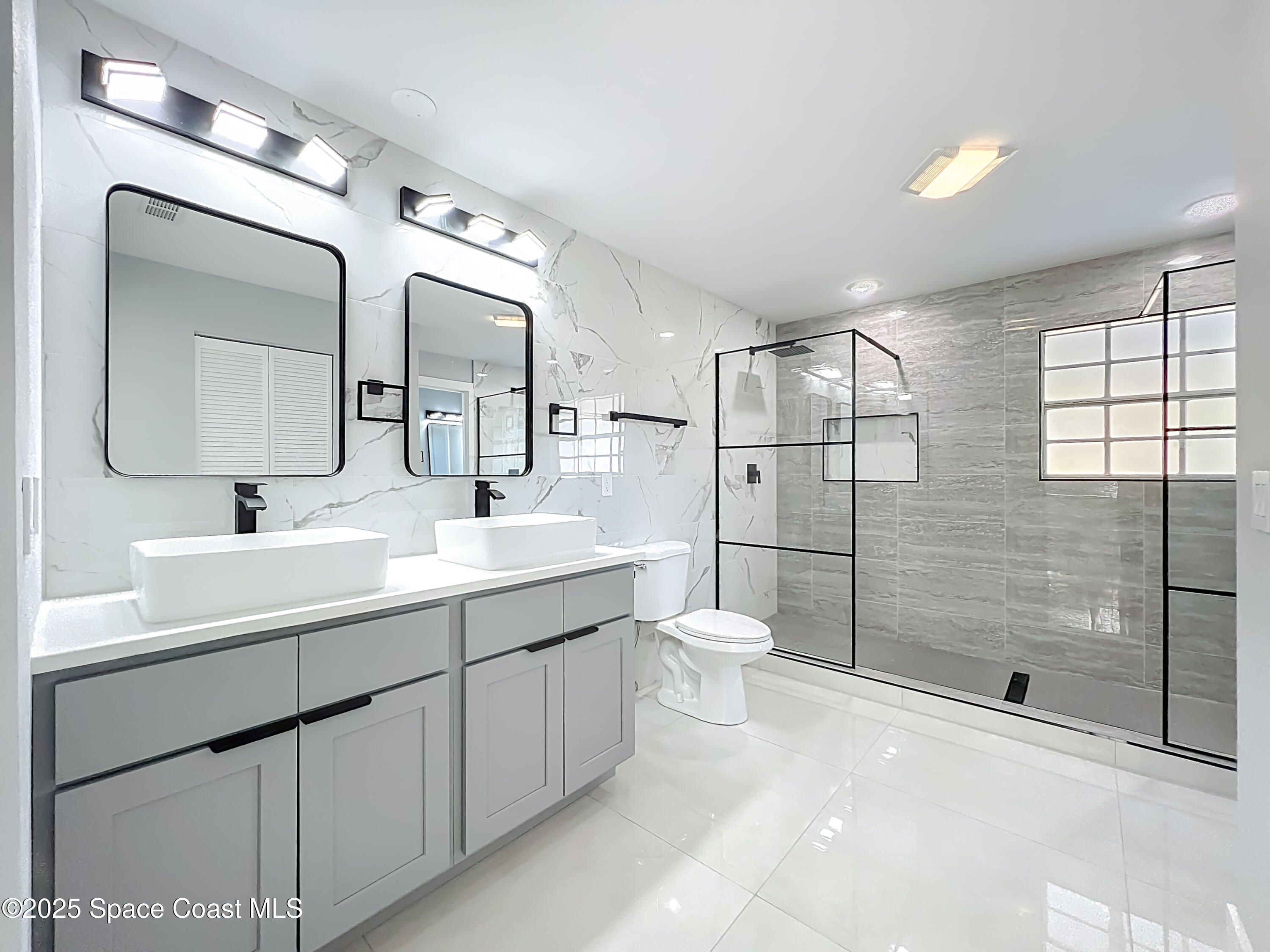 1911 Academy Street Northeast Palm Bay, FL 32905 - Photo 25 of 65 a bathroom with a double vanity sink mirror and toilet