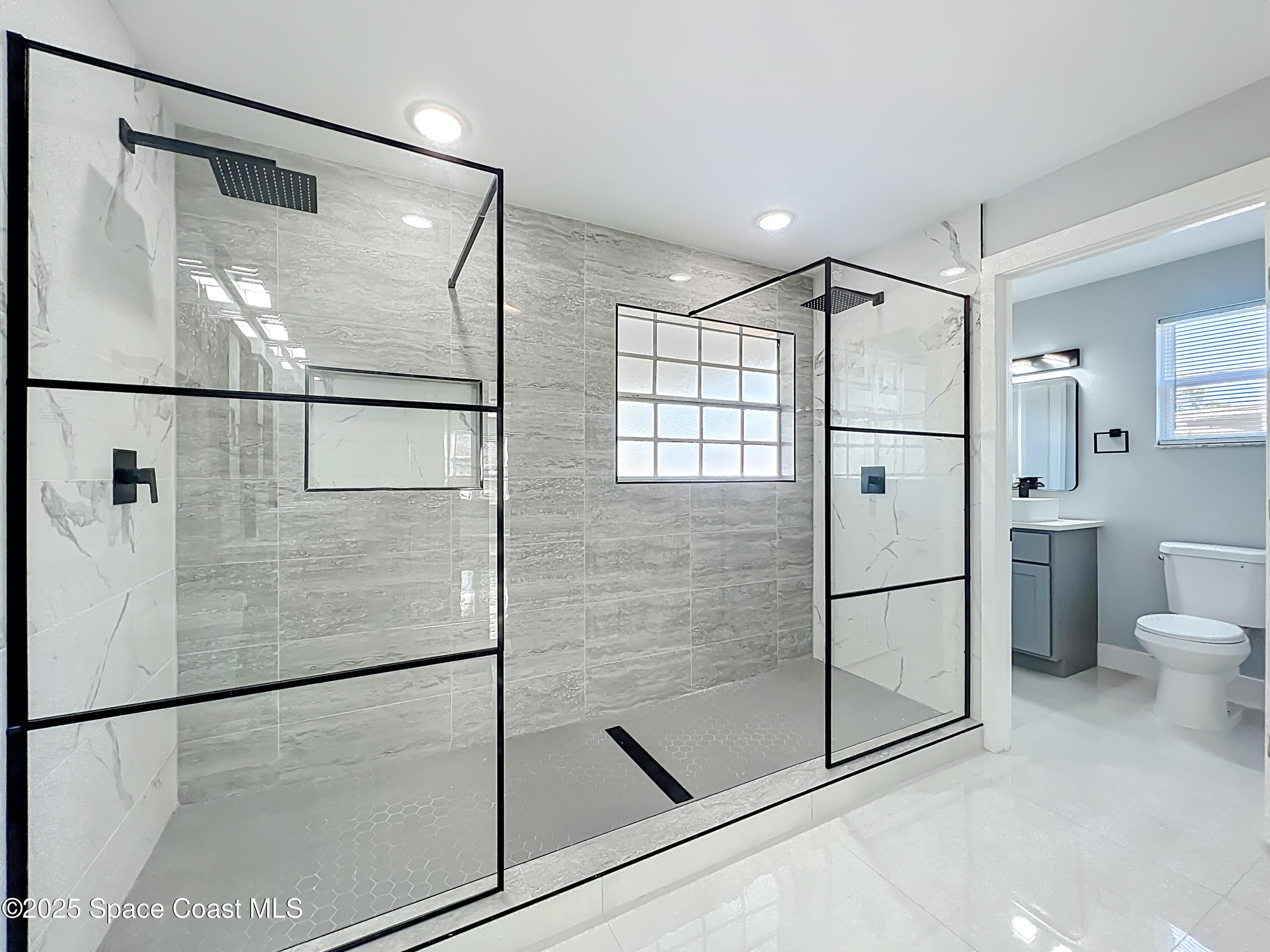 1911 Academy Street Northeast Palm Bay, FL 32905 - Photo 26 of 65 a bathroom with a glass shower door and a glass door shower