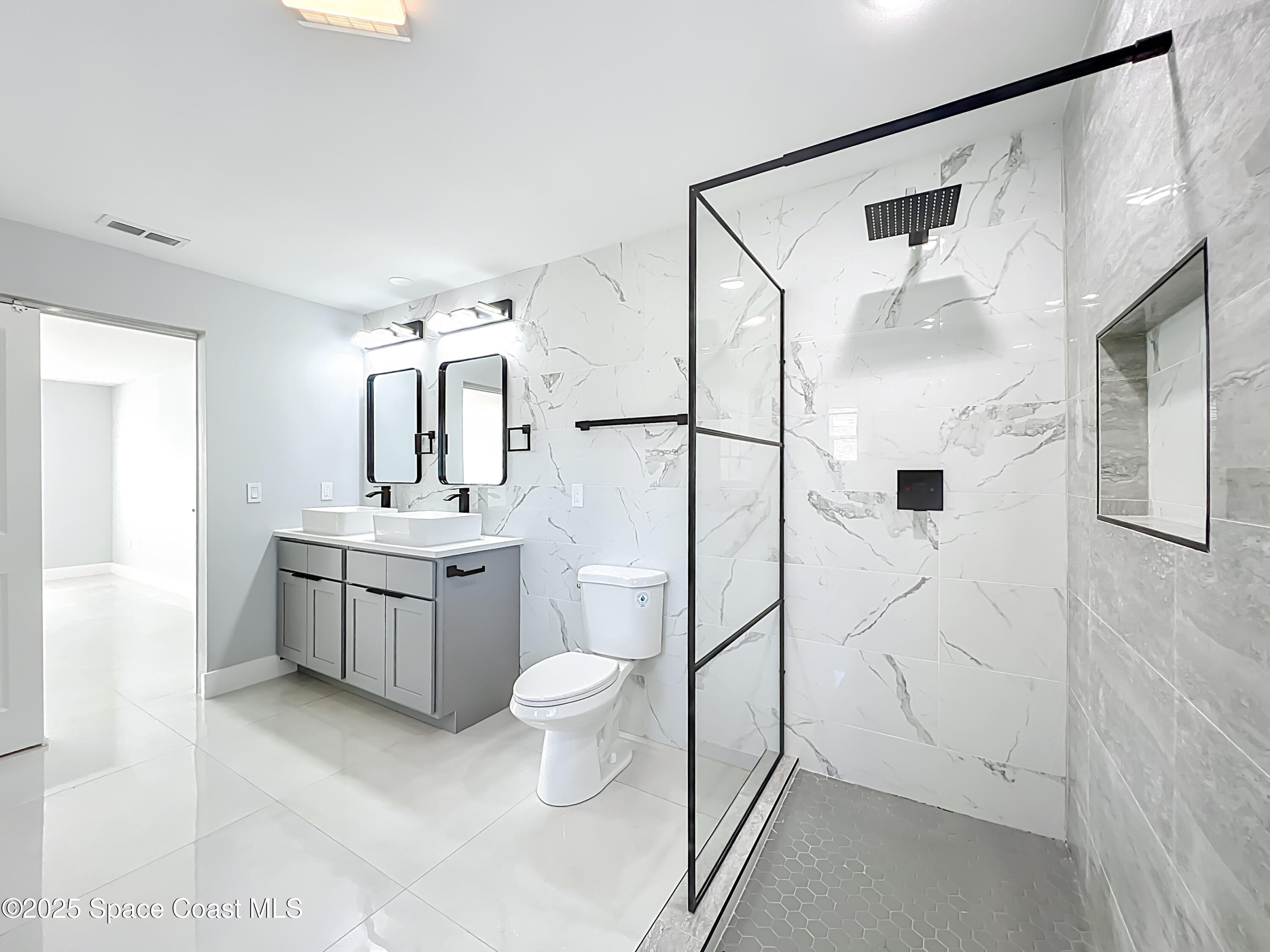 1911 Academy Street Northeast Palm Bay, FL 32905 - Photo 28 of 65 a bathroom with a double vanity sink toilet and shower