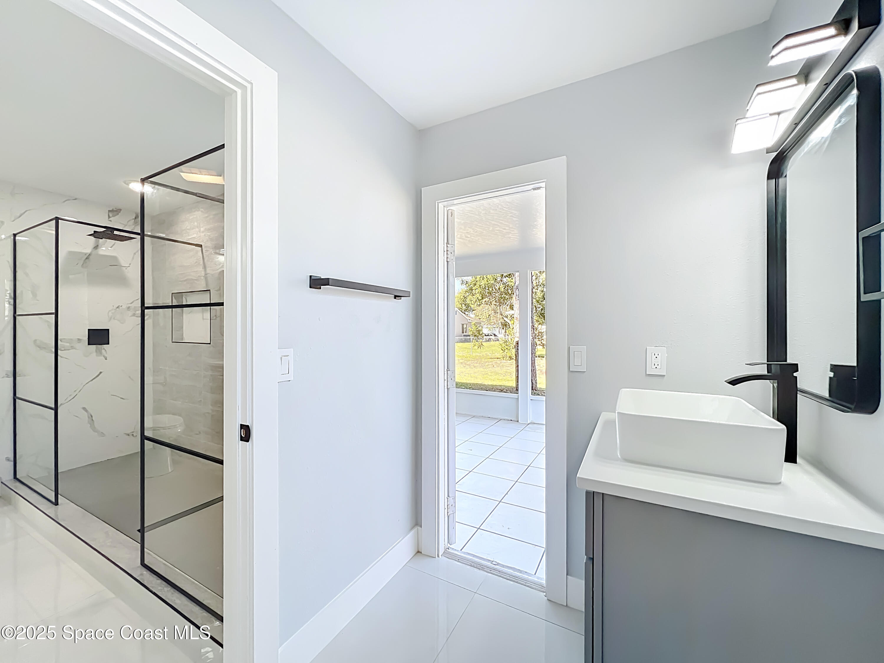 1911 Academy Street Northeast Palm Bay, FL 32905 - Photo 33 of 65 a bathroom with a shower sink and mirror