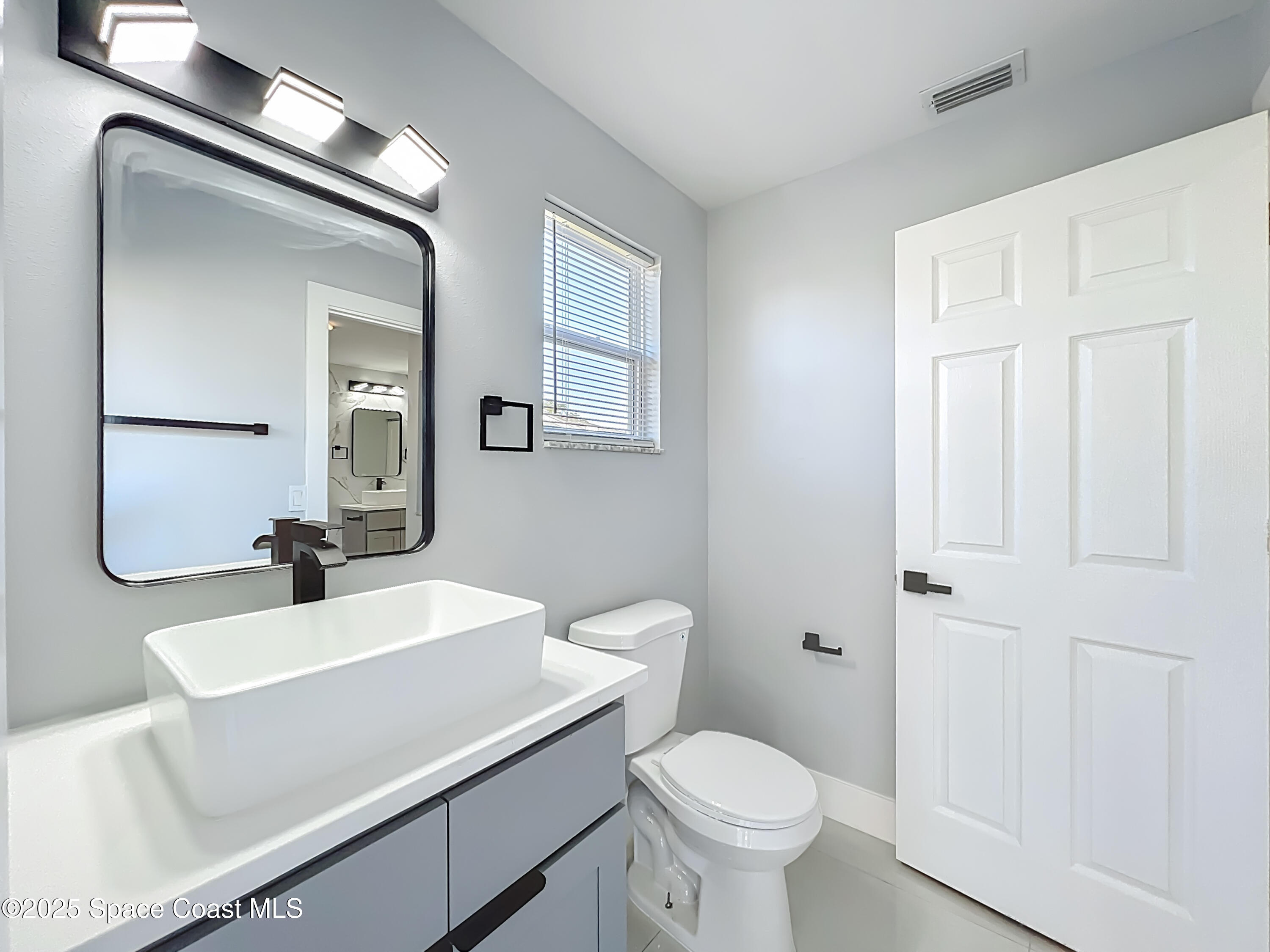 1911 Academy Street Northeast Palm Bay, FL 32905 - Photo 39 of 65 a bathroom with a sink a toilet and shower