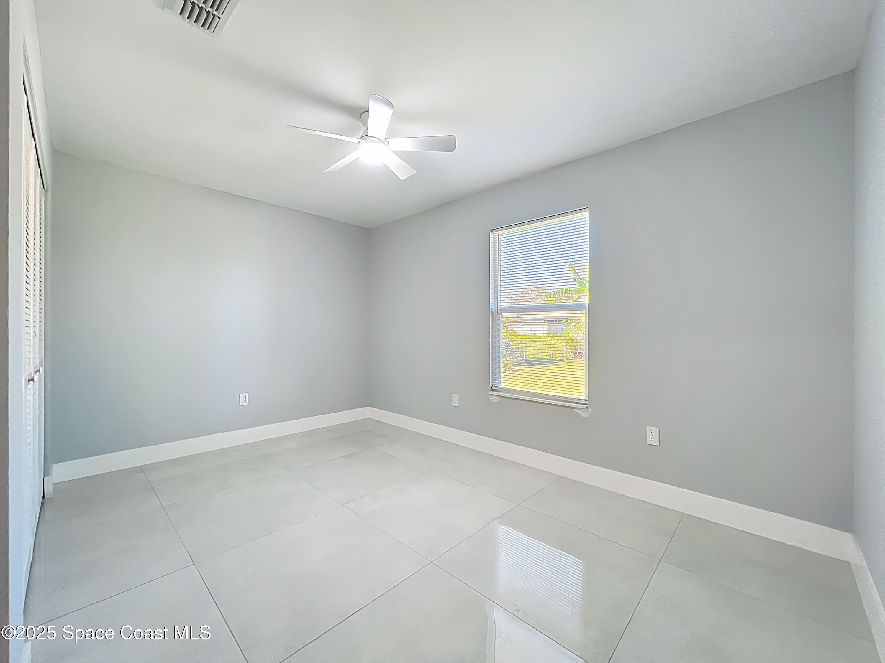 1911 Academy Street Northeast Palm Bay, FL 32905 - Photo 44 of 65 an empty room with a window and a fan