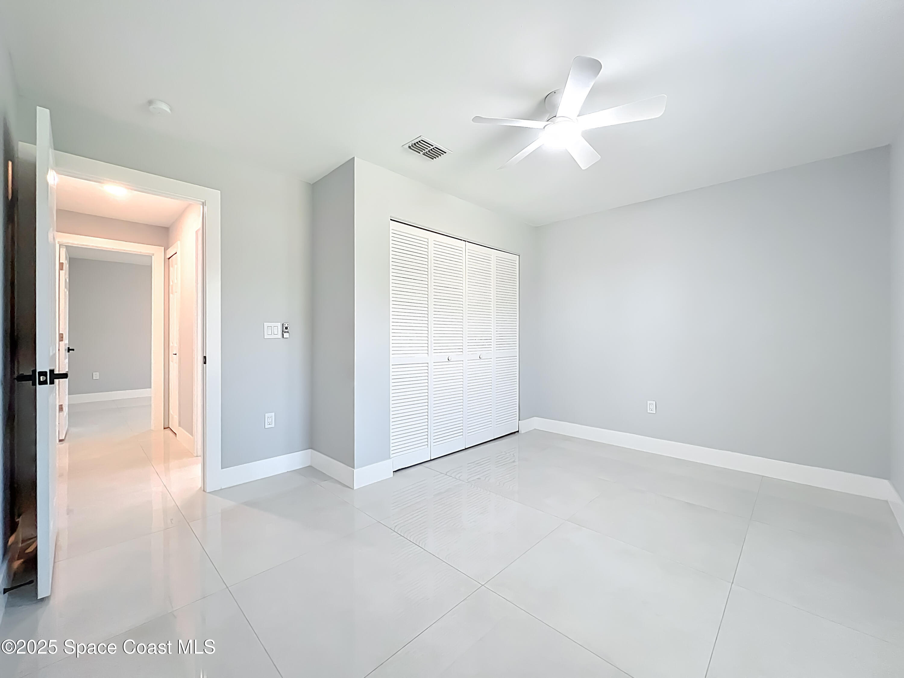 1911 Academy Street Northeast Palm Bay, FL 32905 - Photo 45 of 65 an empty room with a ceiling fan and a bathroom